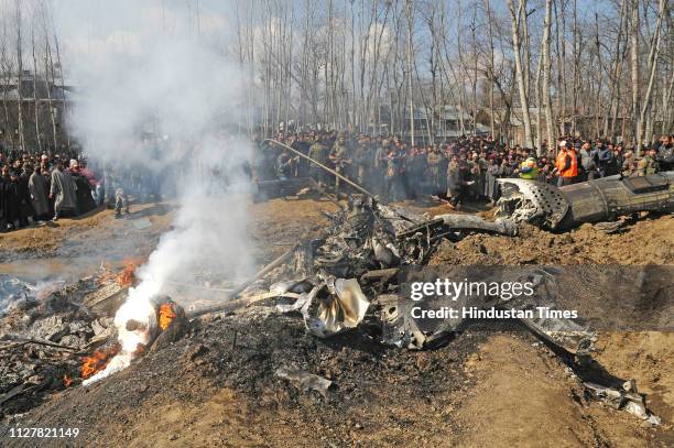 Villagers gather near the wreckage of an Indian Air Force helicopter after it crashed on February 27, 2019 in Budgam, India. Two pilots were killed...