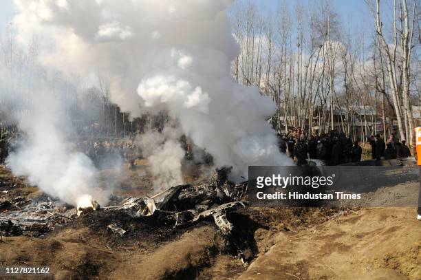 Paramilitary personnel stand near the wreckage of an Indian Air Force helicopter after it crashed on February 27, 2019 in Budgam, India.Two pilots...