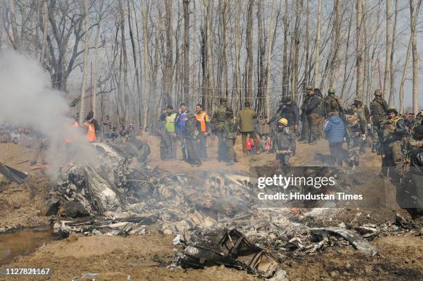 Paramilitary personnel stand near the wreckage of an Indian Air Force helicopter after it crashed on February 27, 2019 in Budgam, India.Two pilots...