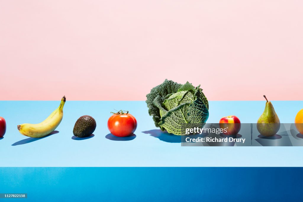 A row of different fruits and vegetables on a table top