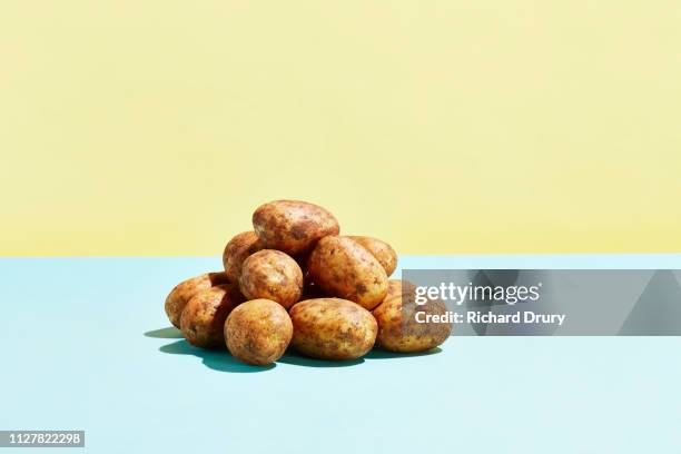 a pile of potatoes on a table top - patata cruda foto e immagini stock