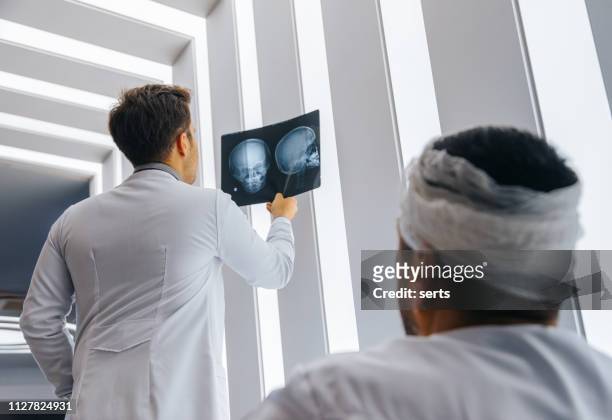 年輕的醫生看病人的頭骨 x 光 - 頭 個照片及圖片檔