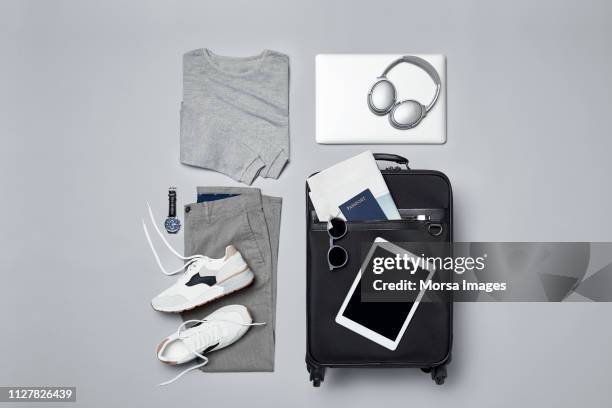 menswear with suitcase and personal accessories - grey trousers stock-fotos und bilder