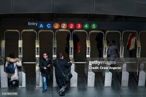 Customers move through the turnstiles at the Fulton Center subway station, February 27, 2019 in New York City. On Wednesday, the Metropolitan...