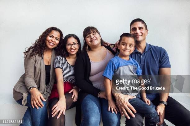 portrait of happy family sitting on bench - family white background stock pictures, royalty-free photos & images