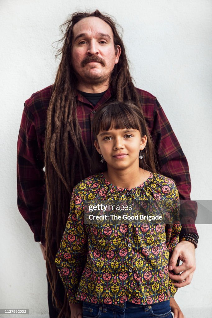 Father standing with arm around young daugher