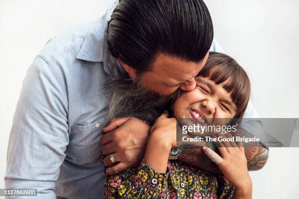 Man kissing daughter on cheek