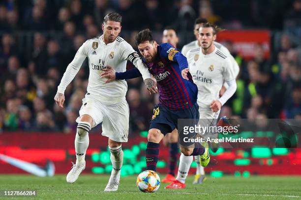Lionel Messi of FC Barcelona competes for the ball with Sergio Ramos of Real Madrid CF during the Copa del Semi Final first leg match between...