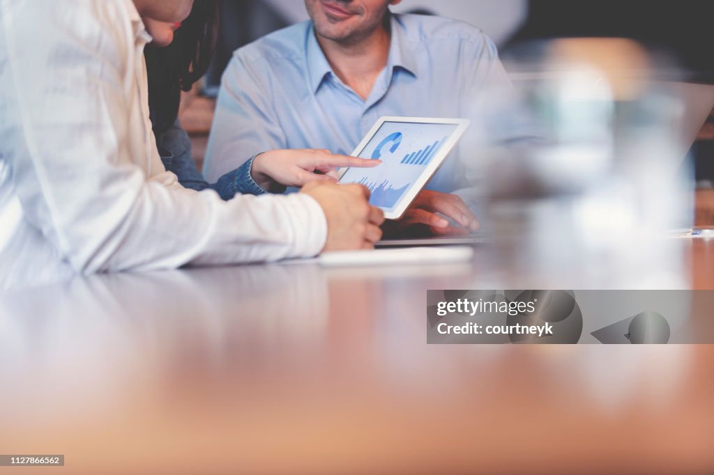 Business people working on financial data on a digital tablet.