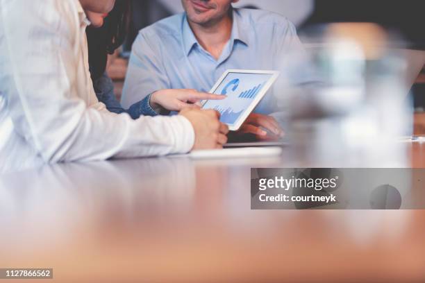 business people working on financial data on a digital tablet. - marketing expertise stock pictures, royalty-free photos & images