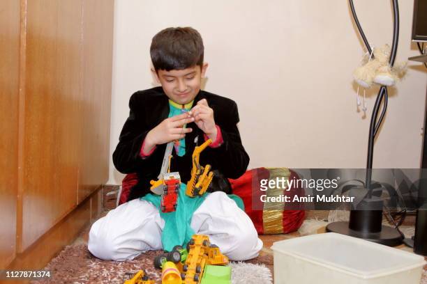 child (boy) playing with toys inside the living room - cute pakistani boys fotografías e imágenes de stock