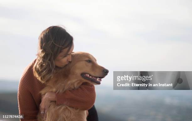 young woman hugging her golden retriever - perro de pura raza fotografías e imágenes de stock