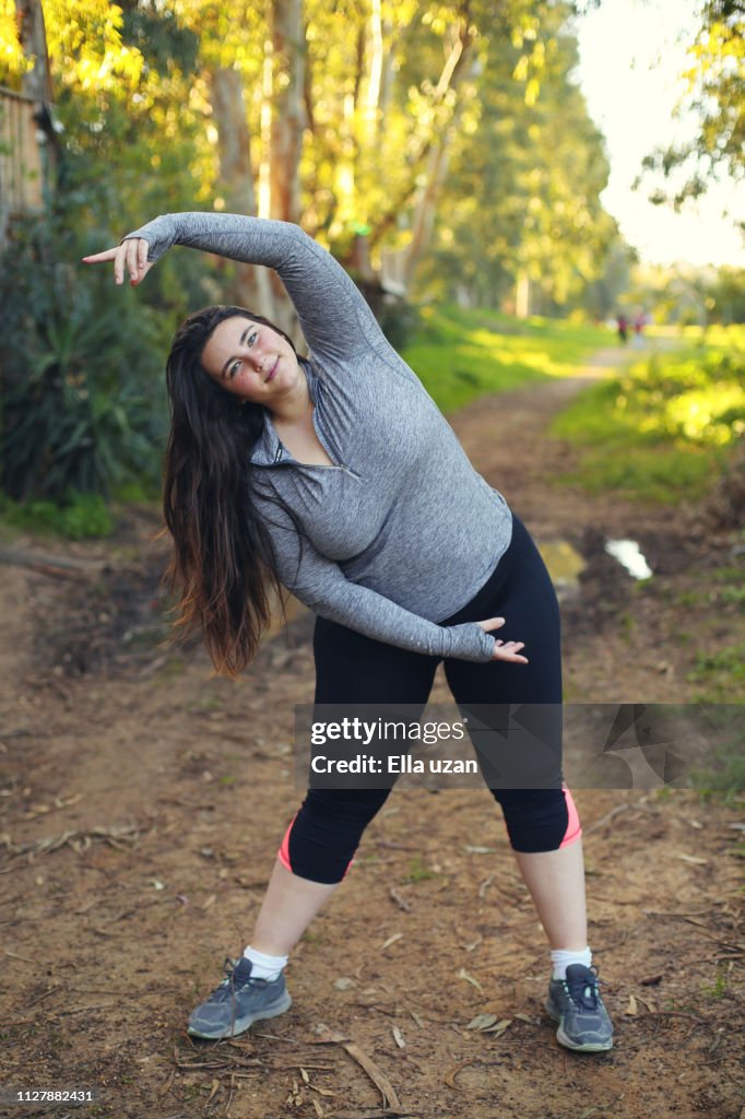 Plus size woman exercising in the park