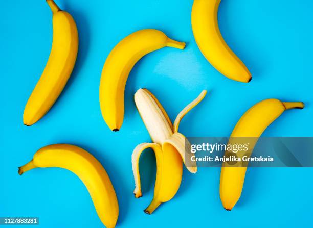 ripe bananas on blue background - banane stock-fotos und bilder