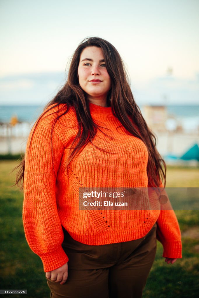 Portrait of plus size woman standing in the park