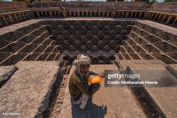 an indian man at chand baori abhaneri. - escher stairs stock pictures, royalty-free photos & images