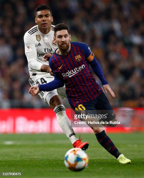 Casemiro of Real Madrid and Leo Messi of Barcelona FC compete for the ball during the Copa del Semi Final match between Real Madrid and Barcelona at...