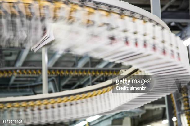 conveyor belts with newspapers in printing press - paper industry stock pictures, royalty-free photos & images