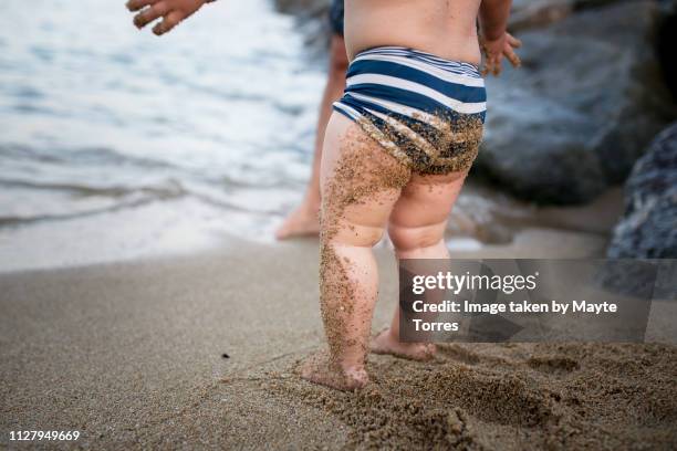 baby boy's butt dirty with sand at the beach - dirty feet stock-fotos und bilder