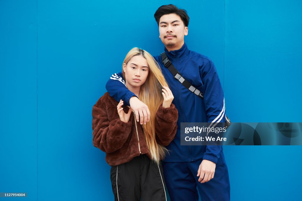 Young man and woman standing casually.