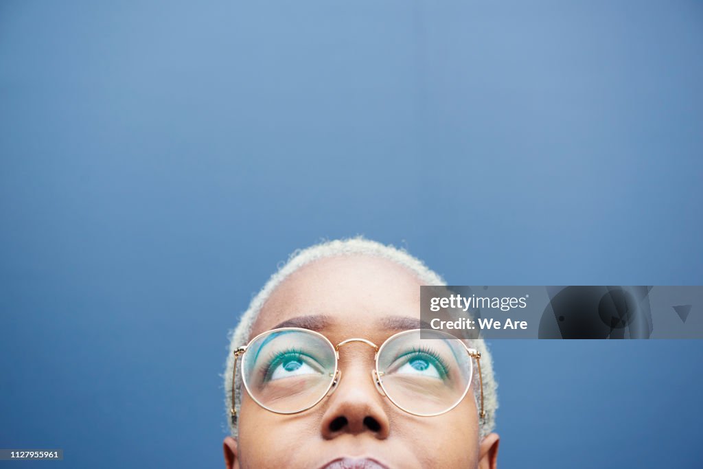Close up of young woman looking up.