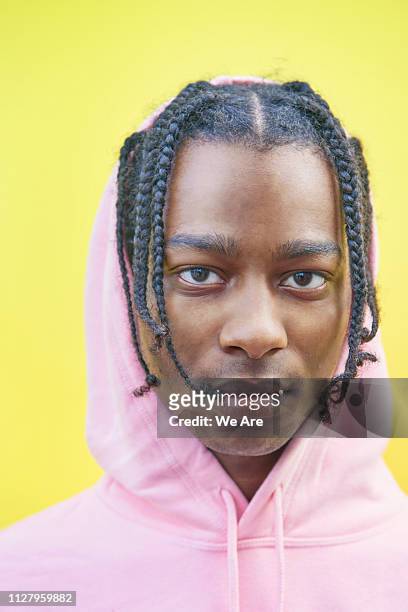 Portrait of young man in pink hooded sweatshirt.