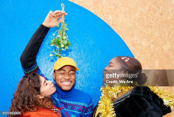 group of friends laughing with mistletoe - mistletoe kiss stockfoto's en -beelden