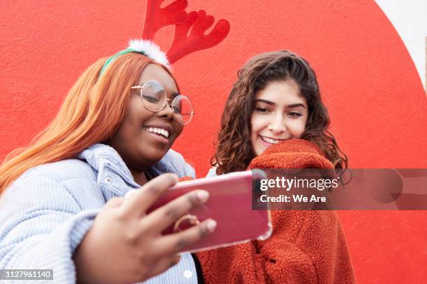 two friends taking a festive selfie - gen z selfie stock pictures, royalty-free photos & images