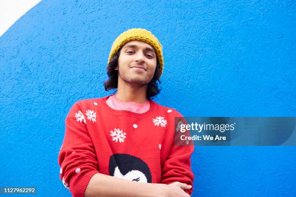 young man in festive sweater - christmas sweater stock pictures, royalty-free photos & images