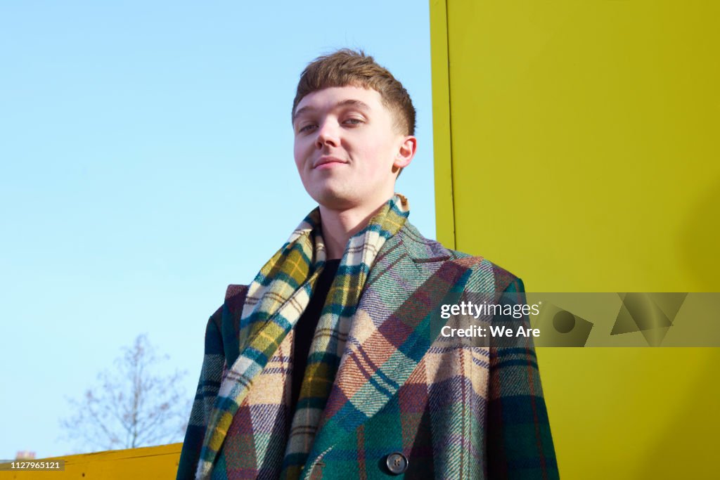 Fashionable young man in tartan coat.