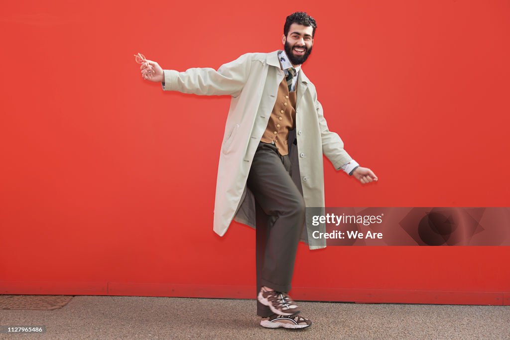 Stylish man posing for camera in playful moment.