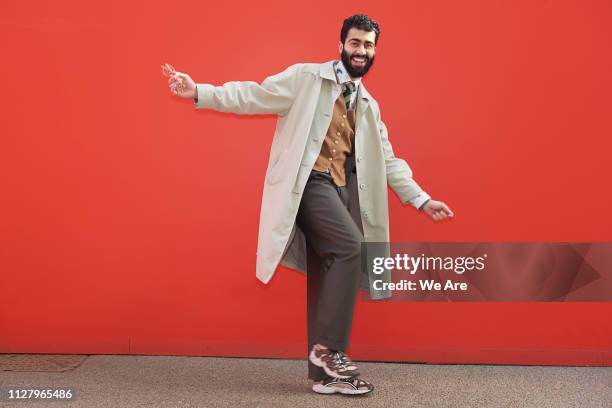 Stylish man posing for camera in playful moment.
