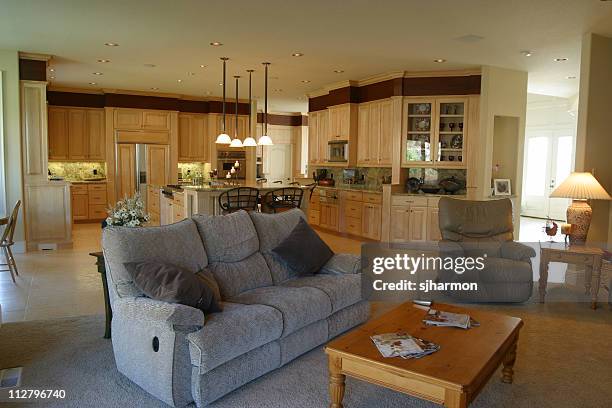 relaxing living room with grey loveseat near kitchen - recliner chair stock pictures, royalty-free photos & images