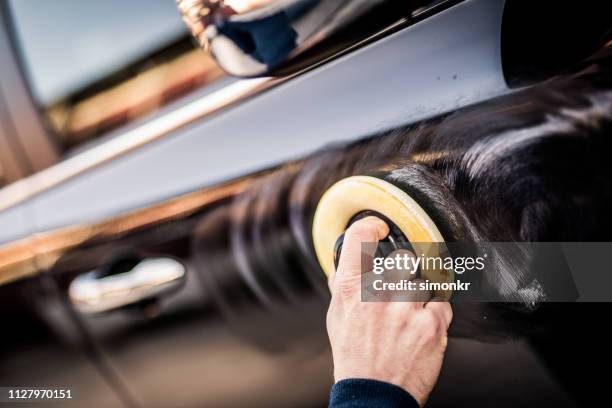 hombre maduro pulido el coche con el pad aplicador - abrillantar fotografías e imágenes de stock