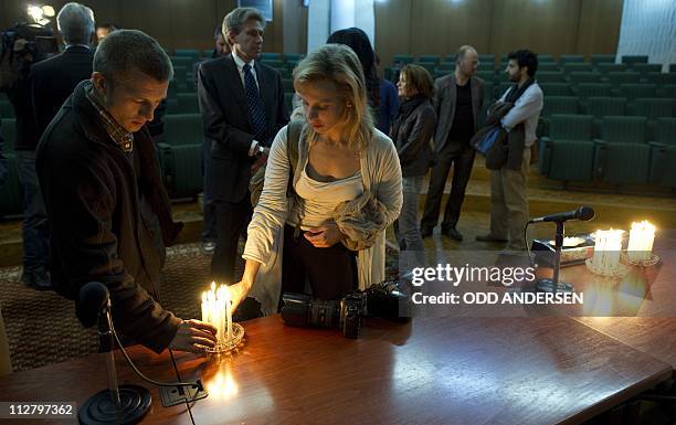 Colleagues light candles at the end of a memorial service for slain photojournalists Tim Hetherington and Chris Hondros in Benghazi on April 21,...