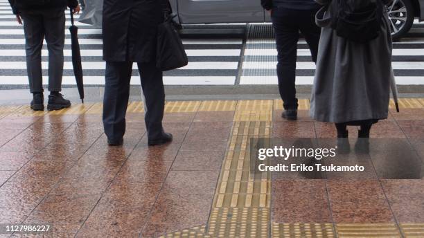 japanese passengers in the rainy city - sad commuter stockfoto's en -beelden