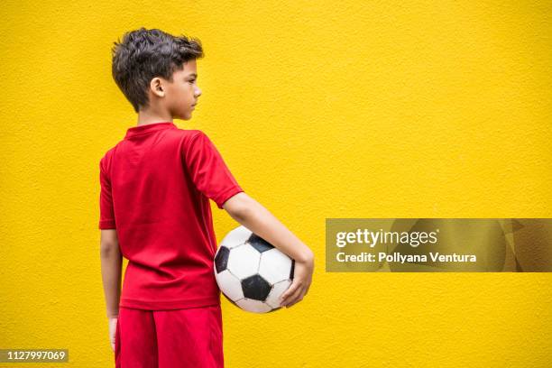 niño sosteniendo una pelota de fútbol - brazilian playing football fotografías e imágenes de stock