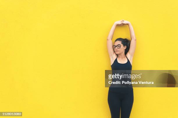 athlete woman training on the yellow background - good posture stock pictures, royalty-free photos & images