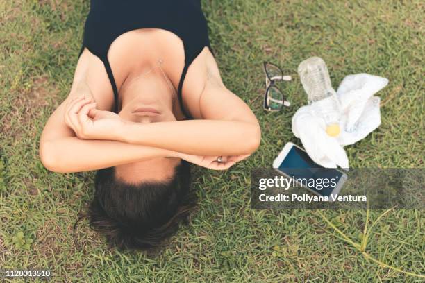 atleta agotado acostado en la hierba - fainting fotografías e imágenes de stock