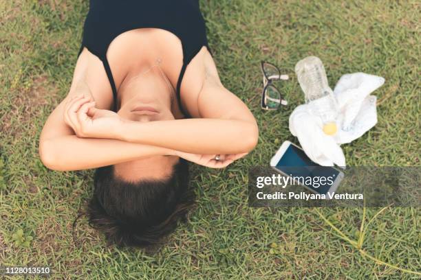 精疲力竭的運動員躺在草地上 - fainting 個照片及圖片檔