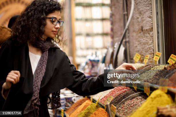 woman shopping in spice shop in grand bazaar, istanbul, turkey - bazar de especiarias imagens e fotografias de stock
