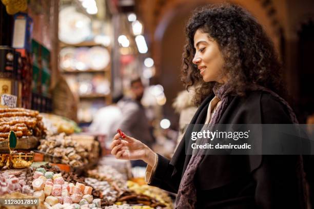 junge frau einkaufen in türkischem honig shop im großen basar, istanbul, türkei - frau kauft lebensmittel stock-fotos und bilder
