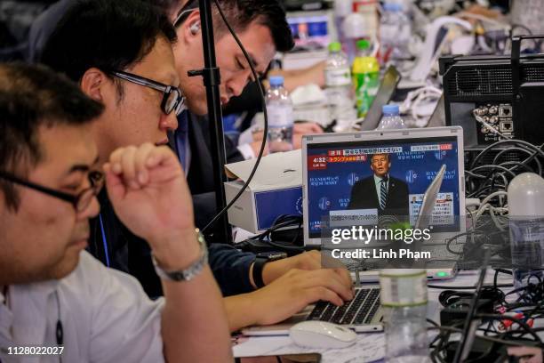 Journalists work at a media centre as the press conference by US President Donald Trump is telecasted following the second US-North Korea summit on...