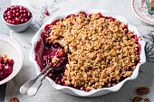 Cranberry crumble, crisp in a baking dish. Grey background. Close up.