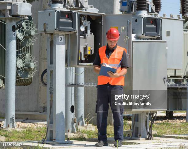 distribution system operator checking equipment in electricity substation. - transformer imagens e fotografias de stock