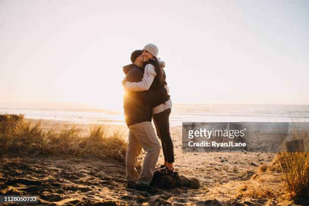 älteres paar umarmt, an der küste von oregon zu lieben - couple dunes stock-fotos und bilder
