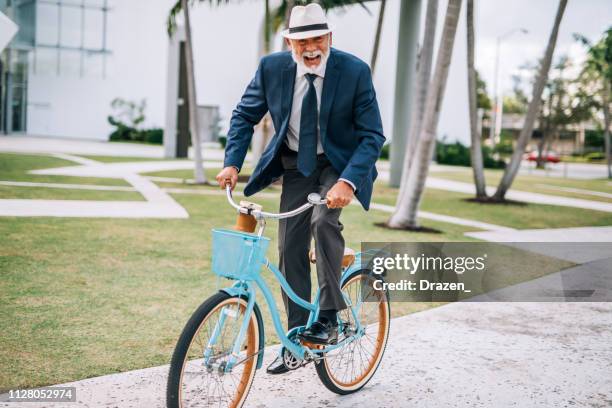 porträt von senior latino mann tragen anzug und hemd in usa und reiten fahrrad - miami fahrrad stock-fotos und bilder