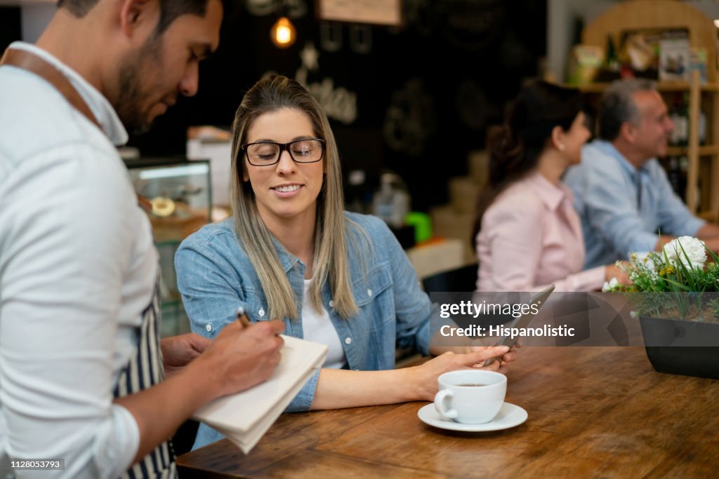 Pretty Young Customer Ordering Something To Waiter Writing Down The ...
