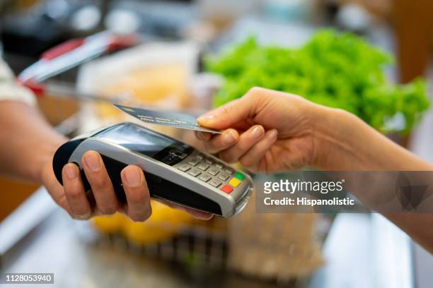 スーパー マーケットでの非接触型決済を行う認識できない顧客のクローズ アップ - クレジットカードリーダ ストックフォトと画像