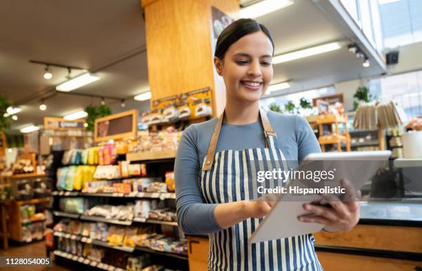vrouwelijke manager bij een supermarkt holding tablet glimlachen - chef cuisine stockfoto's en -beelden